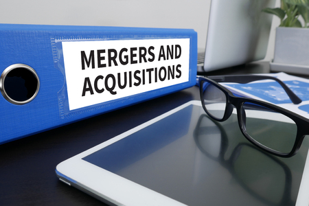 55235151 - m&amp;a (mergers and acquisitions) office folder on desktop on table with office supplies. ipad